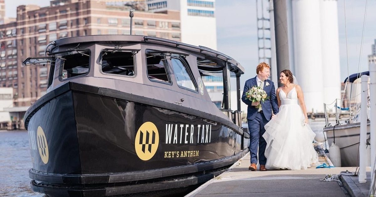 A wedding couple walking the dock beside Key's Anthem