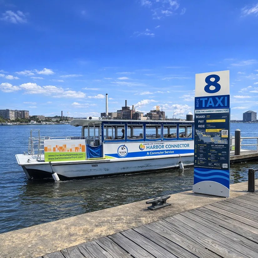 A Harbor Connector boat docked beside the stop 8 water taxi sign