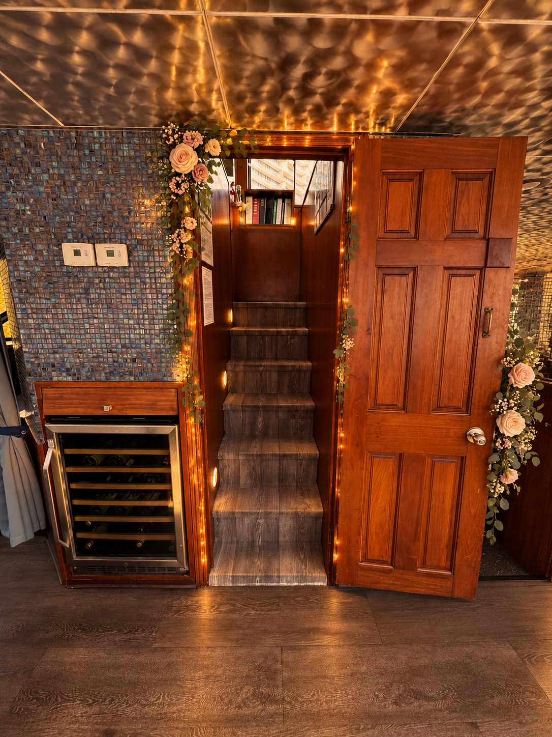 The staircase aboard Lady Thames framed with a garland of roses and fairy lights