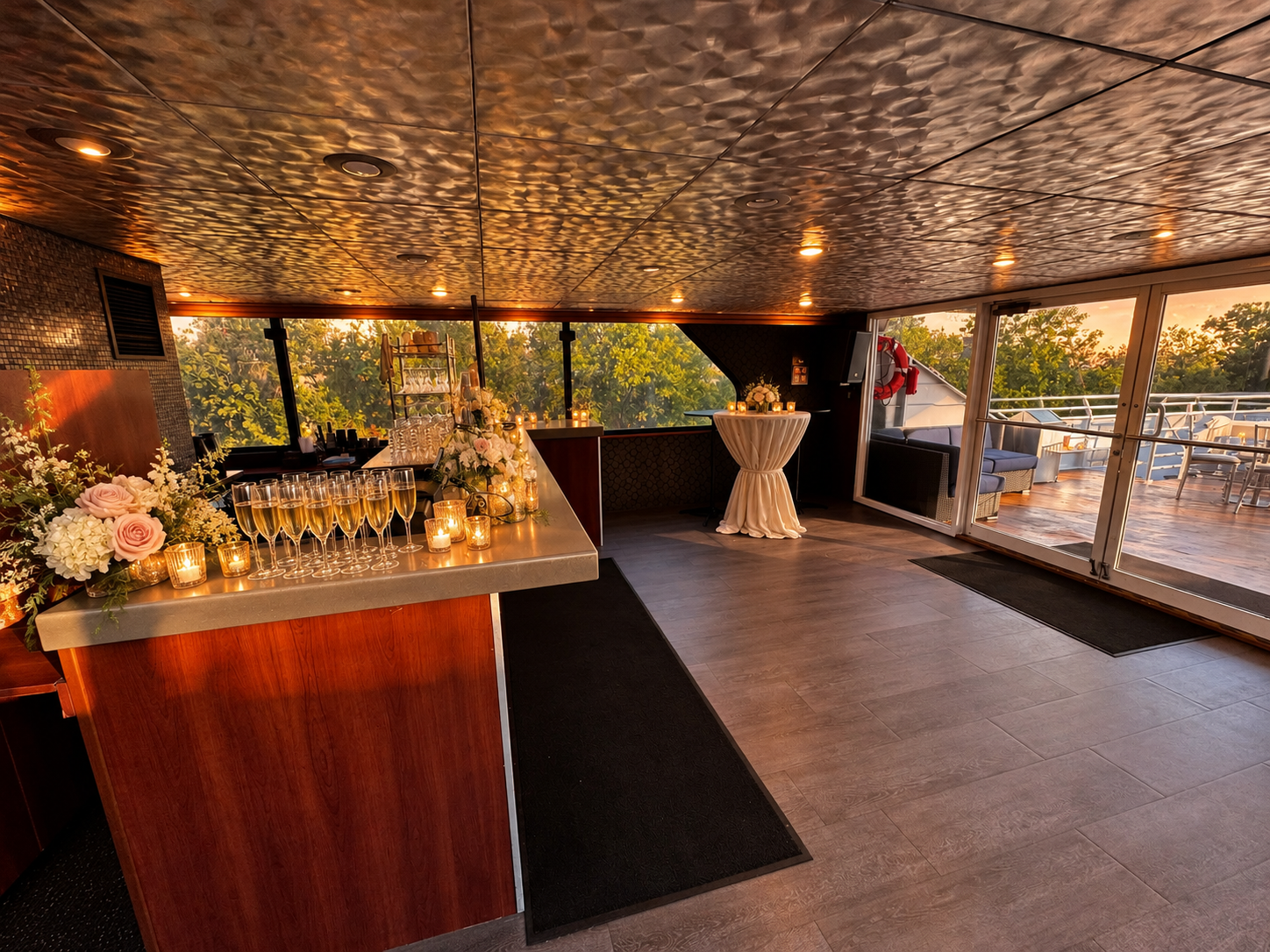 Champagne and florals set on the bar aboard Lady Thames, with doors open to the deck