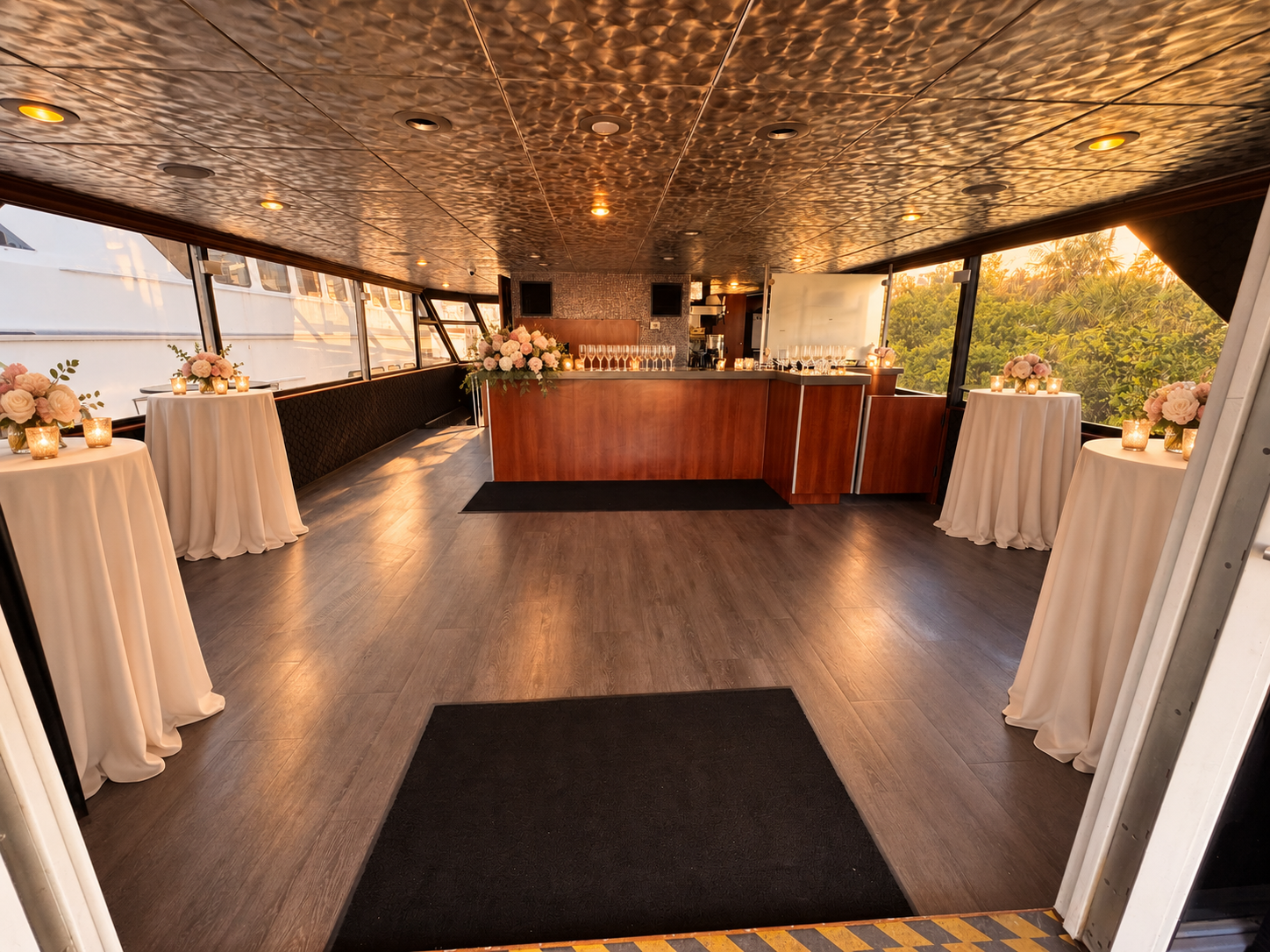 The upper salon of Lady Thames set for cocktail hour with linen-draped high-top tables