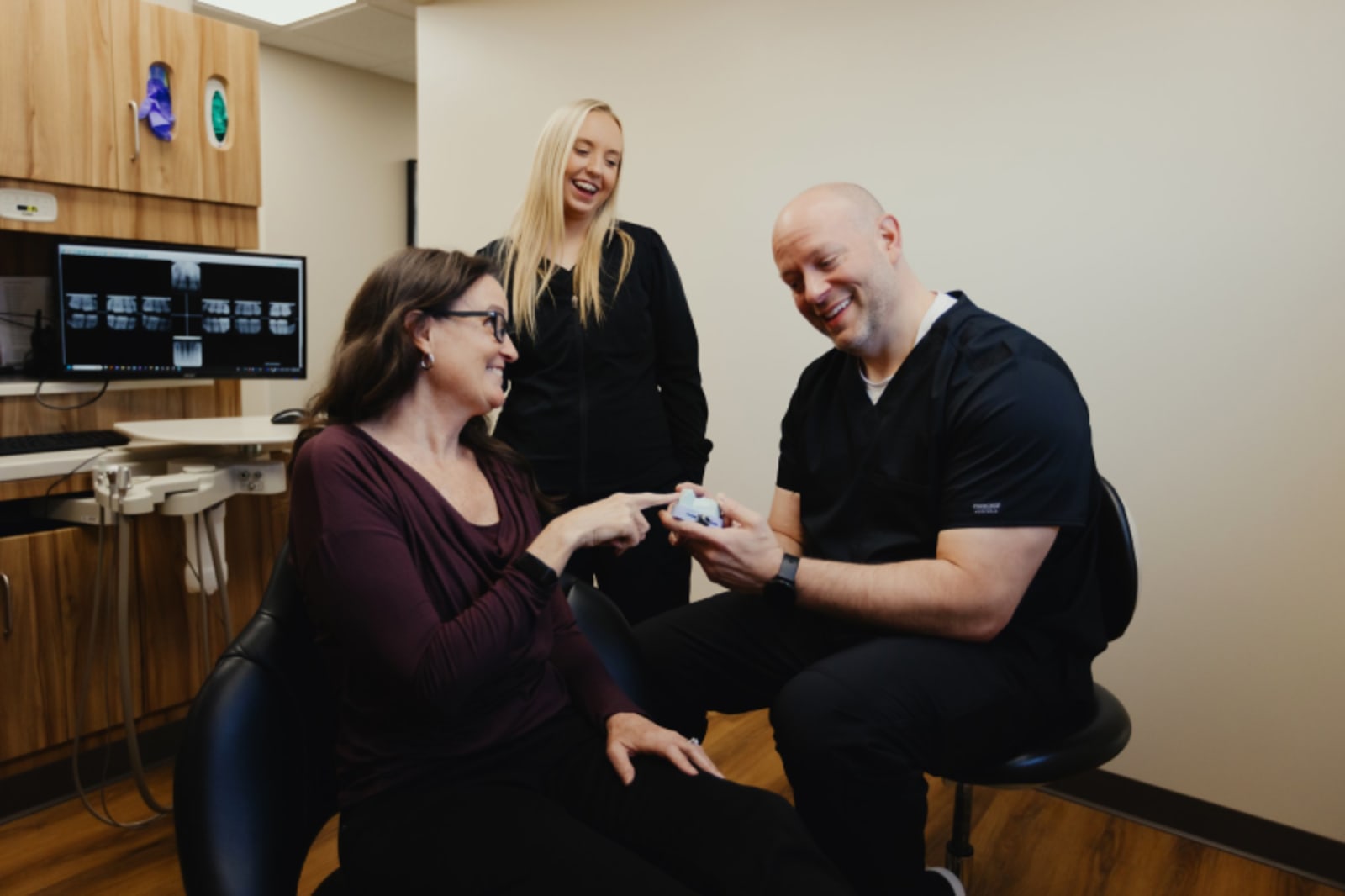 Dental professional explaining procedure to patient in treatment room