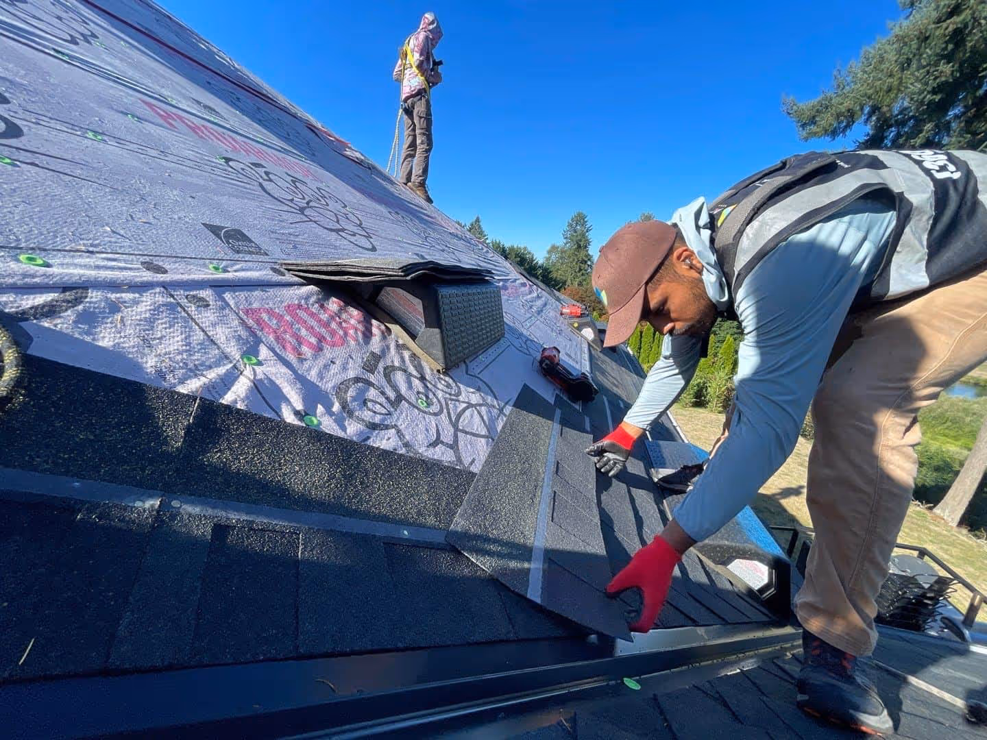 Roof replacement in progress with shingles being installed by professional roofer on a residential home