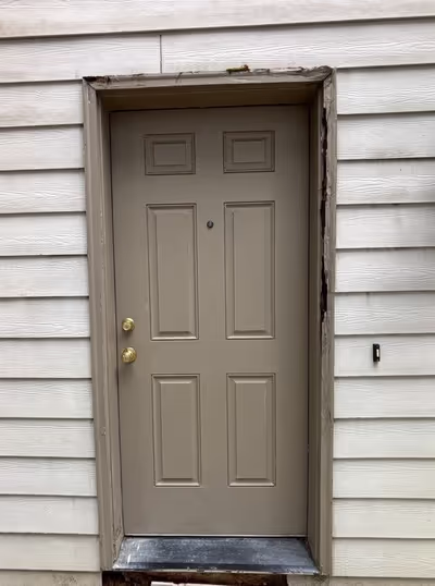 Door trim with significant dry rot, the texture of the wood looks soft and crumbly. 