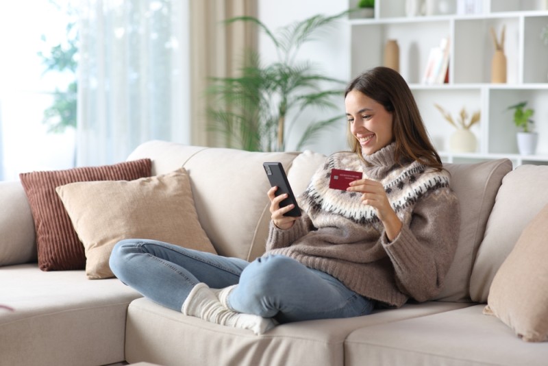 femeie pe canapea foloseste telefonul
