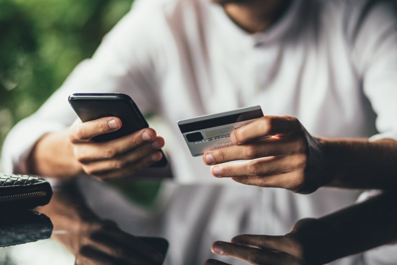 O imagine cu un om care studiaza pe telefon procesul de refinantare a unui credit