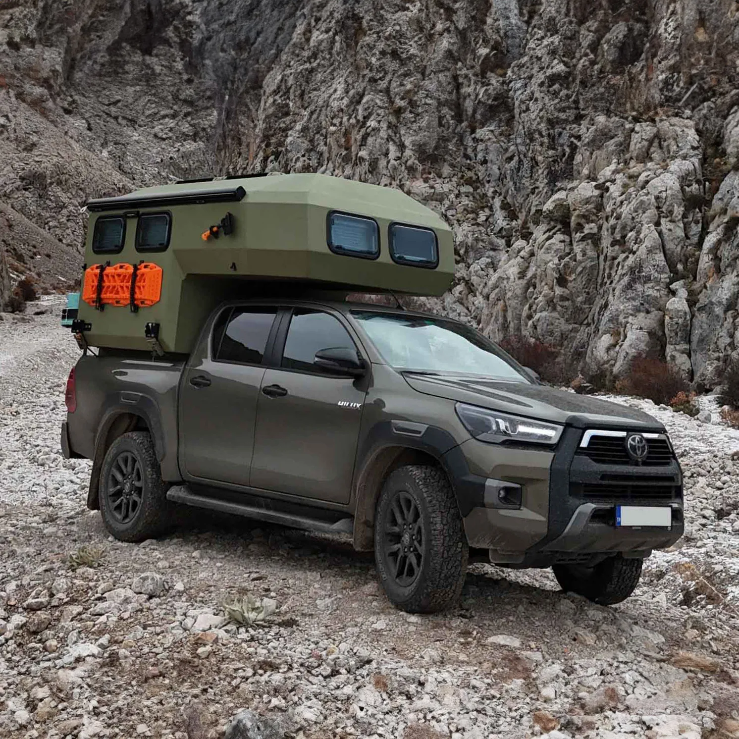 Uozi camper on a 4x4 pickup on rocky mountain terrain