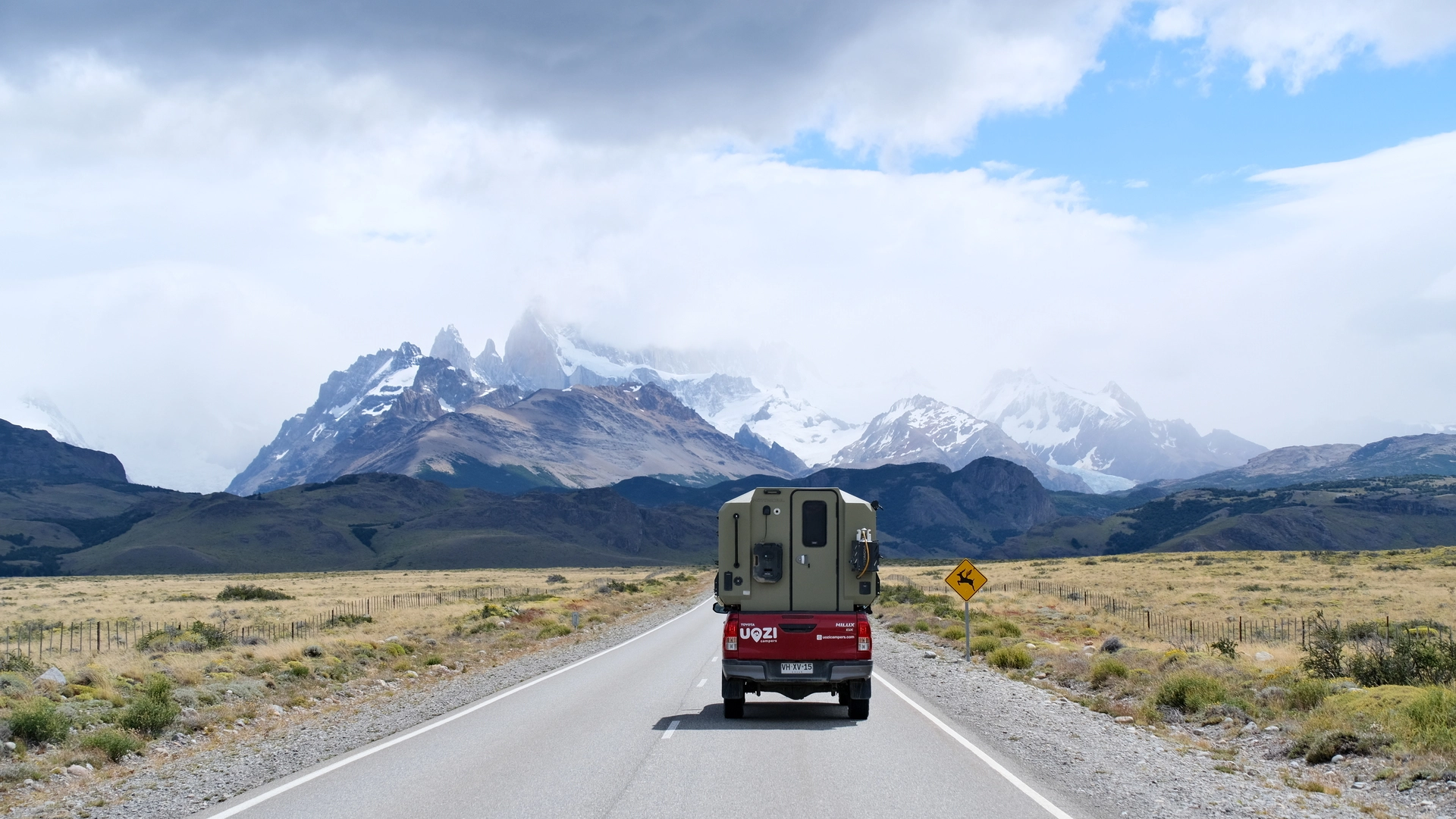Uozi camper van rental on a scenic Patagonia road with snow-capped mountains, Chile