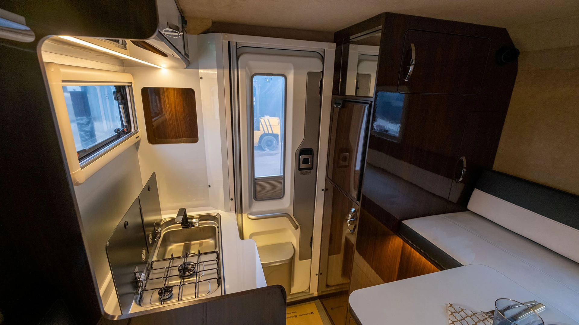Interior of a Uozi camper with kitchen, table and entry door