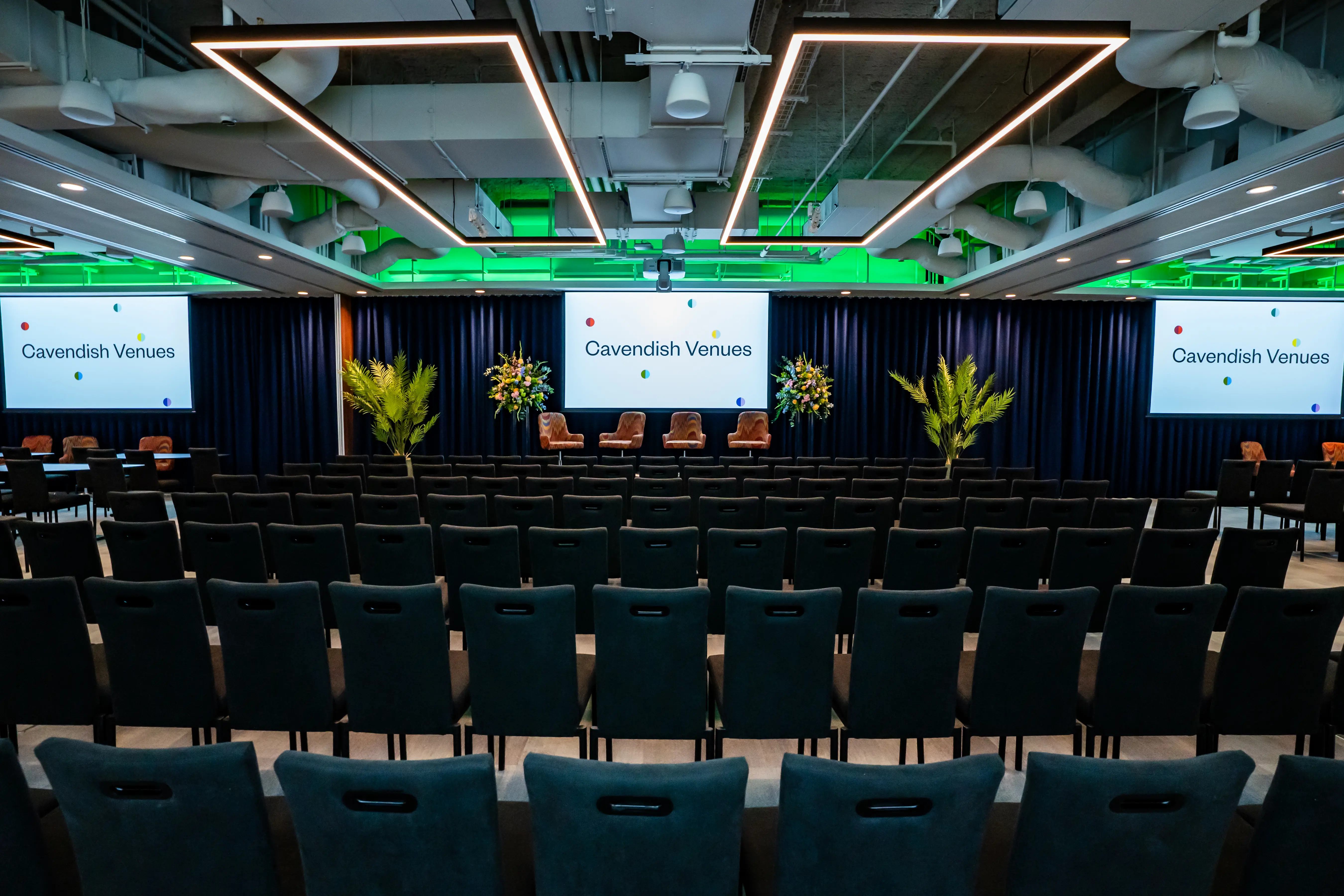 The auditorium at 1 Basinghall Avenue set theatre style, with screens and green accent lighting