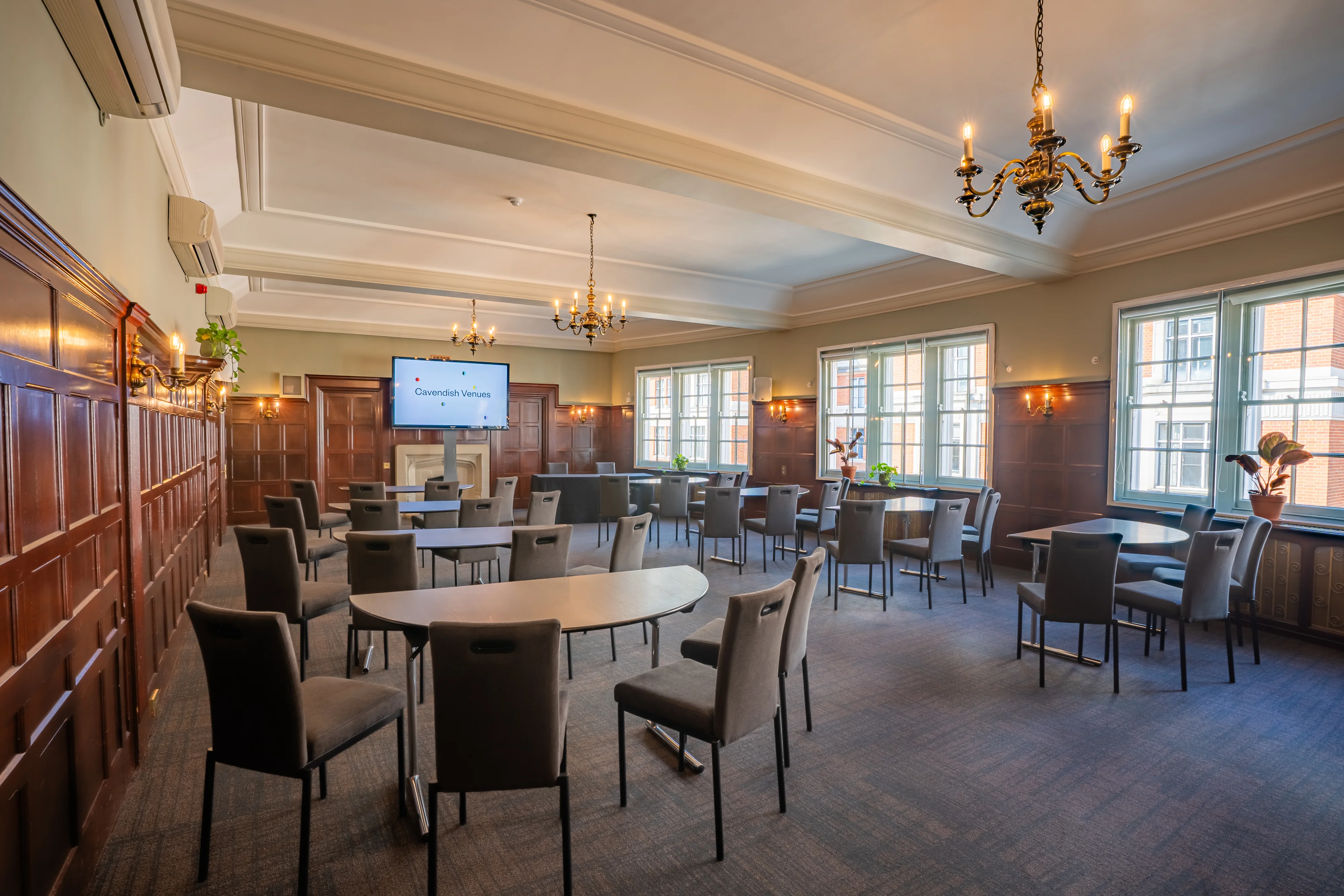 The Oxford Suite at 44 Hallam Street set out cabaret style beneath chandeliers