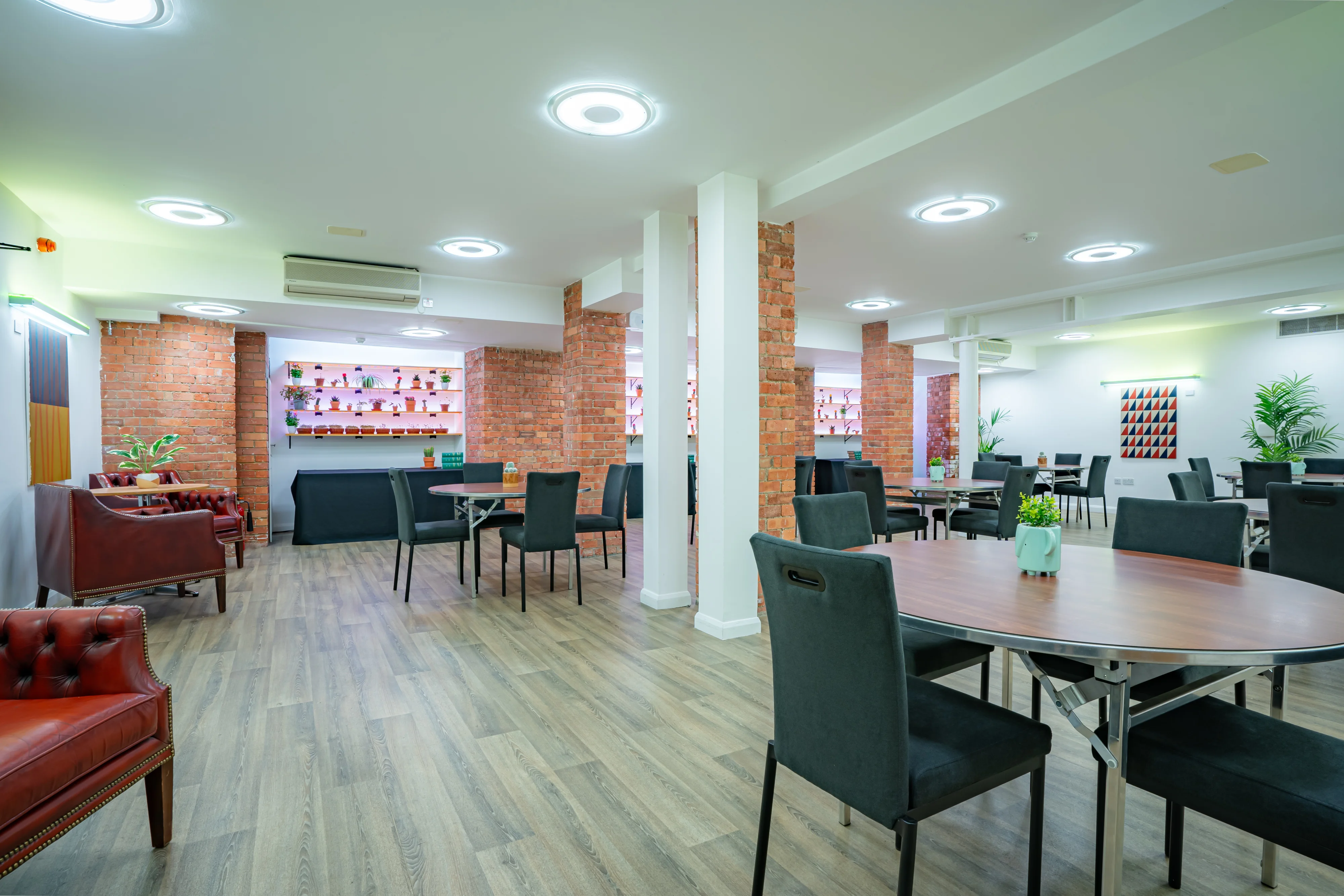 The cafe area at 44 Hallam Street, with exposed brick walls and soft seating