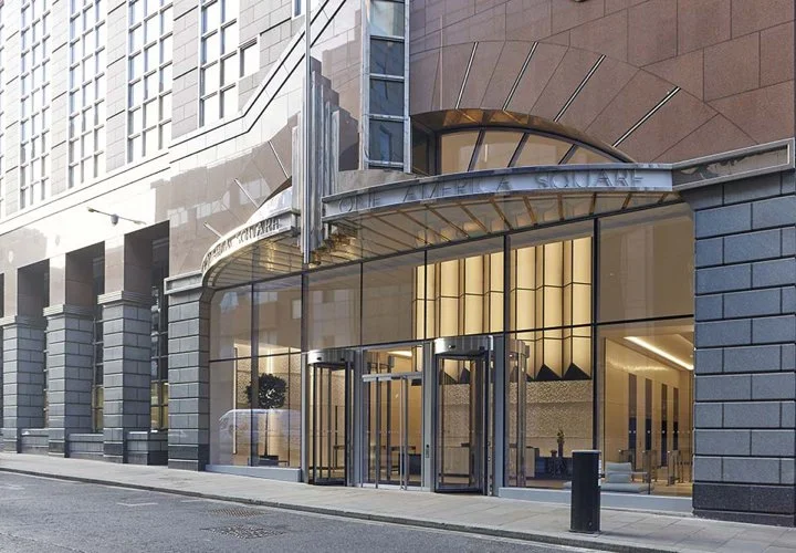 The street entrance to 1 America Square, with revolving doors set into the stone facade