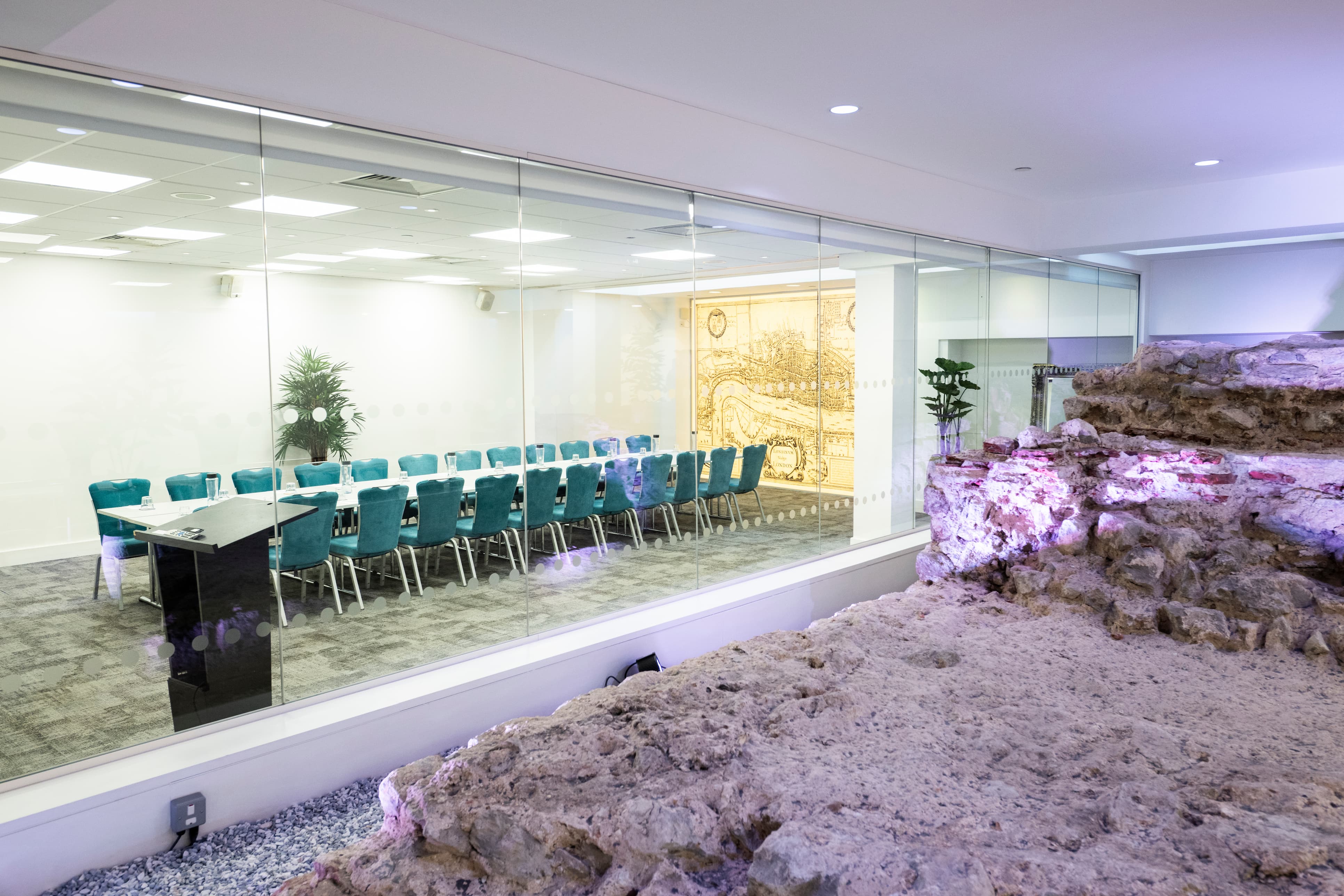 The Walbrook Suite at 1 America Square, overlooking the floodlit Roman London Wall through a glass wall