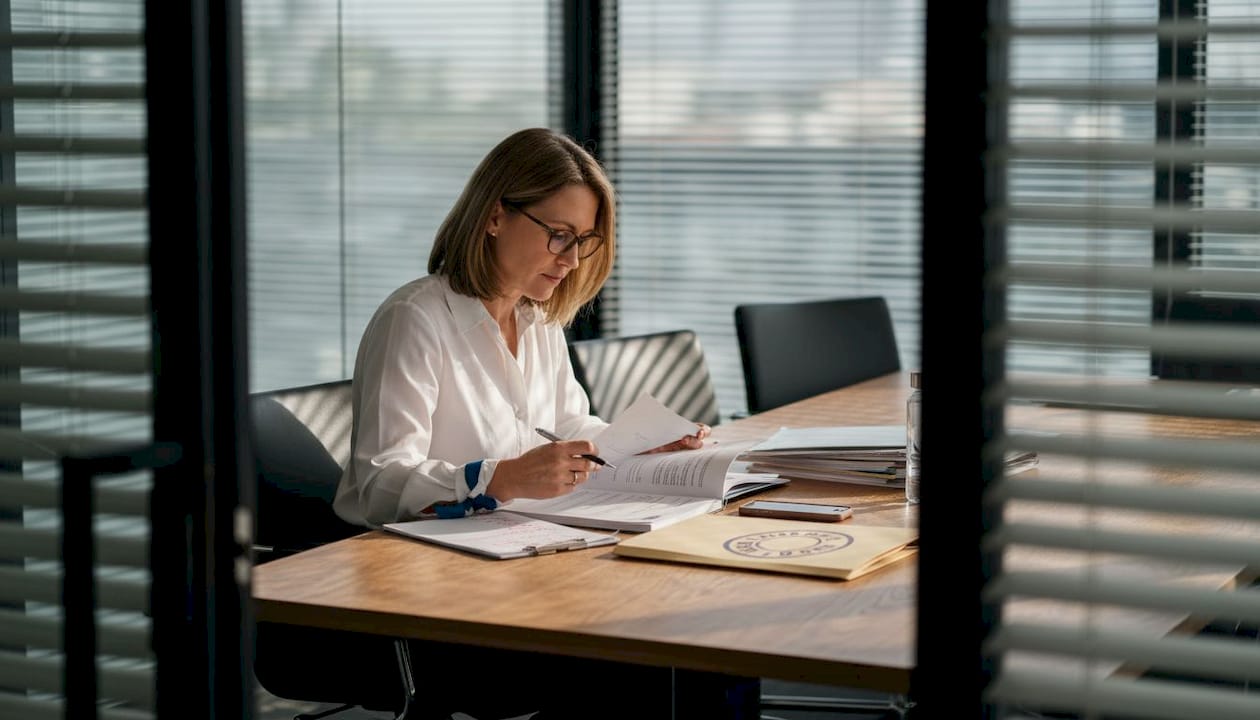 Accountant reviewing compliance documents in boardroom