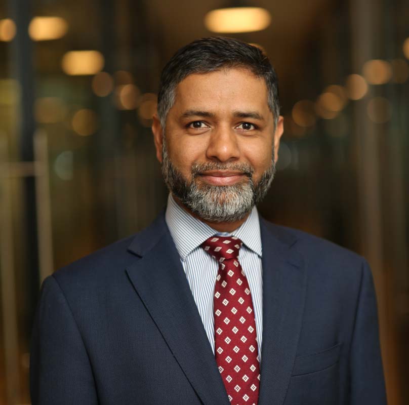 A professional accountant in a navy blue suit, representing the expertise and trustworthiness required for supporting tech start-ups with compliance and funding.