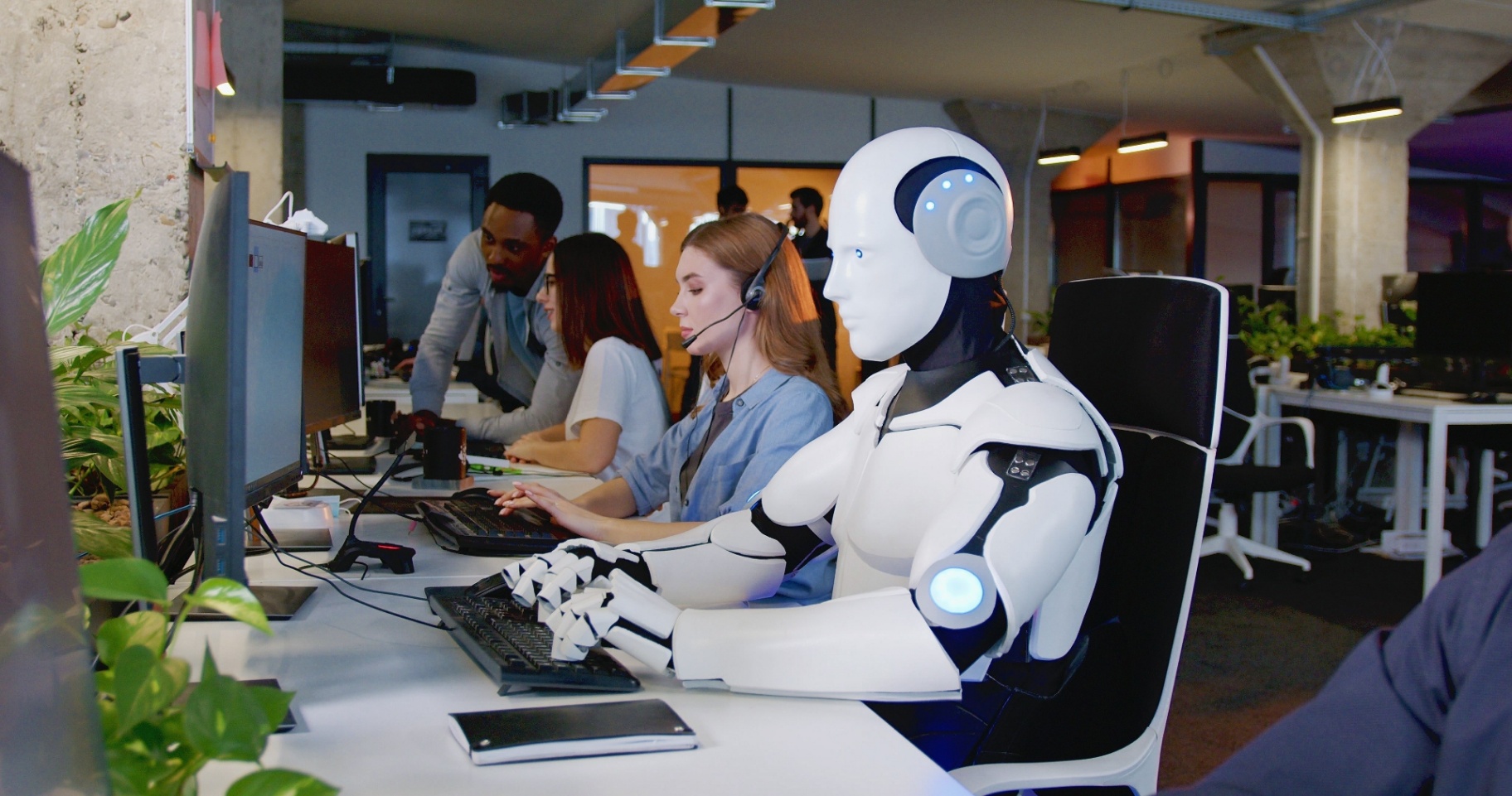 A team of skilled professionals and a humanoid robot working side by side at computers in a modern office, symbolising the collaboration between human expertise and advanced AI technology in 2026 accounting.