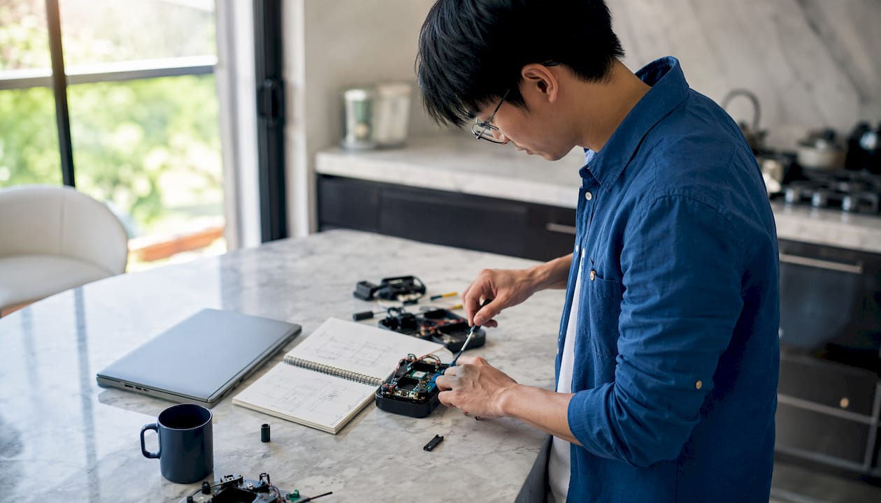 Startup founder assembling prototype in coworking space