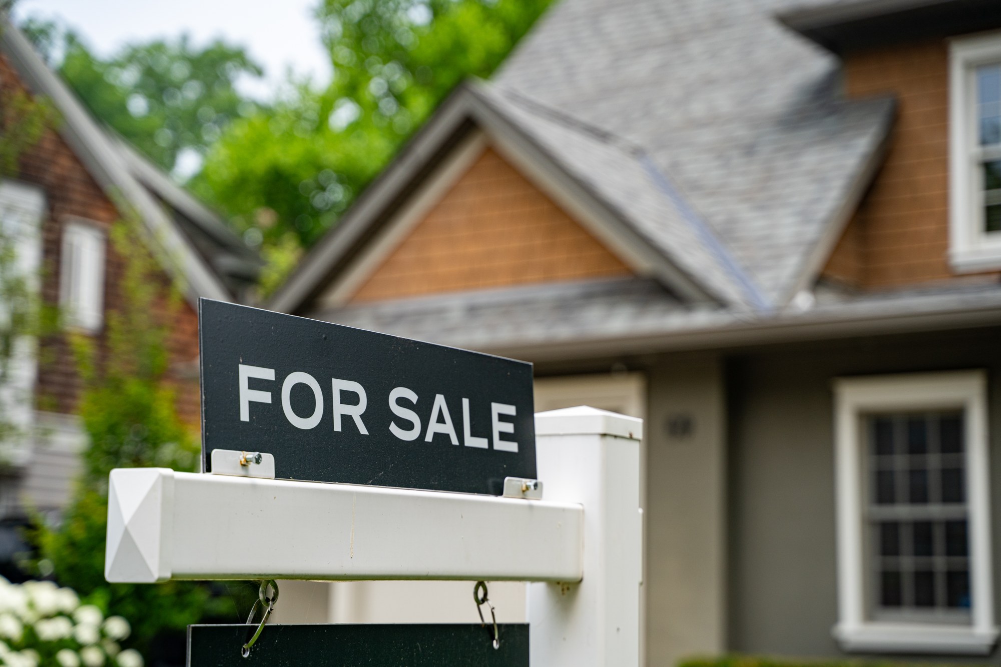 A For Sale sign in front of a house