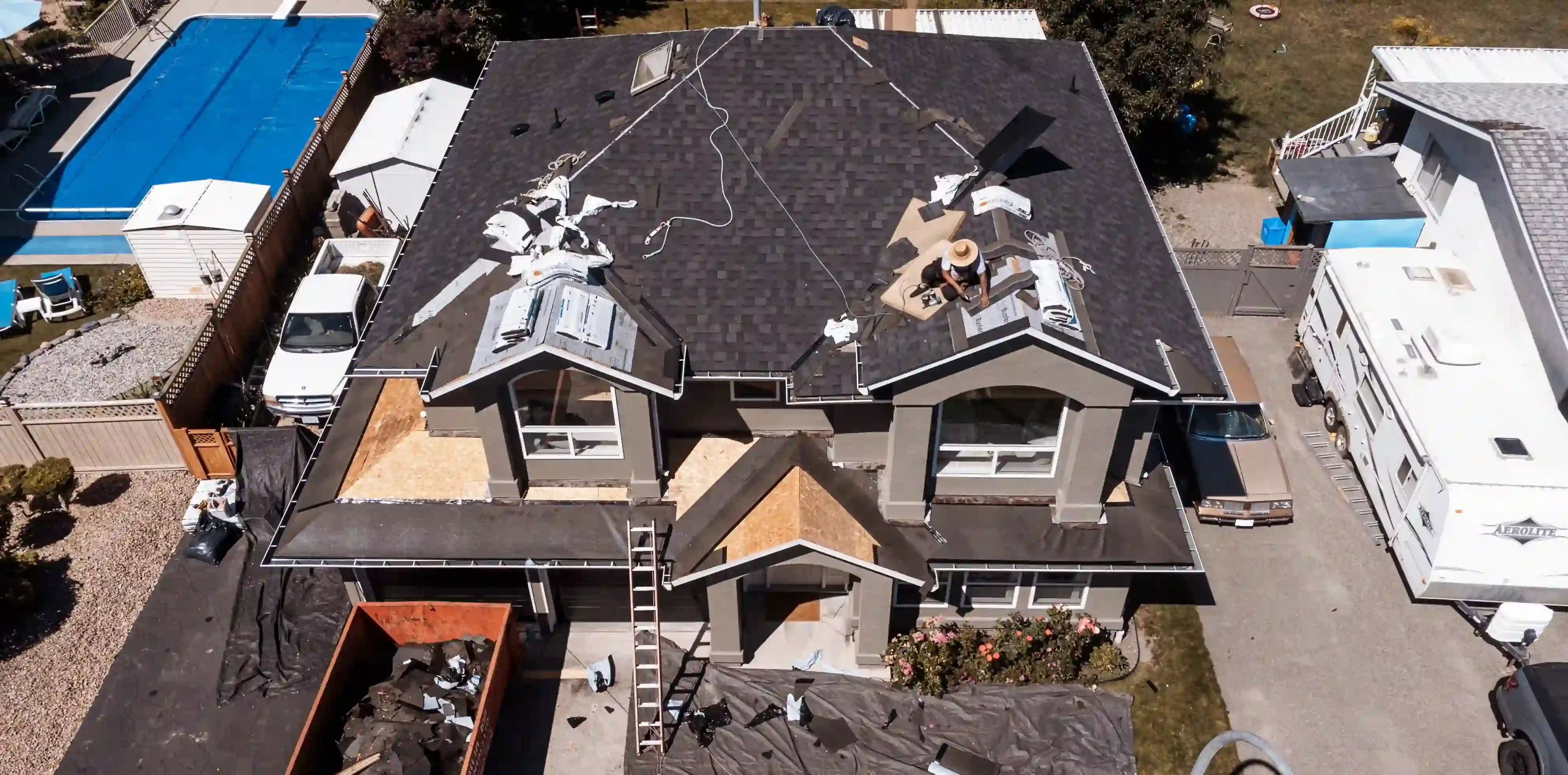 aerial view of residential home roof being repaired