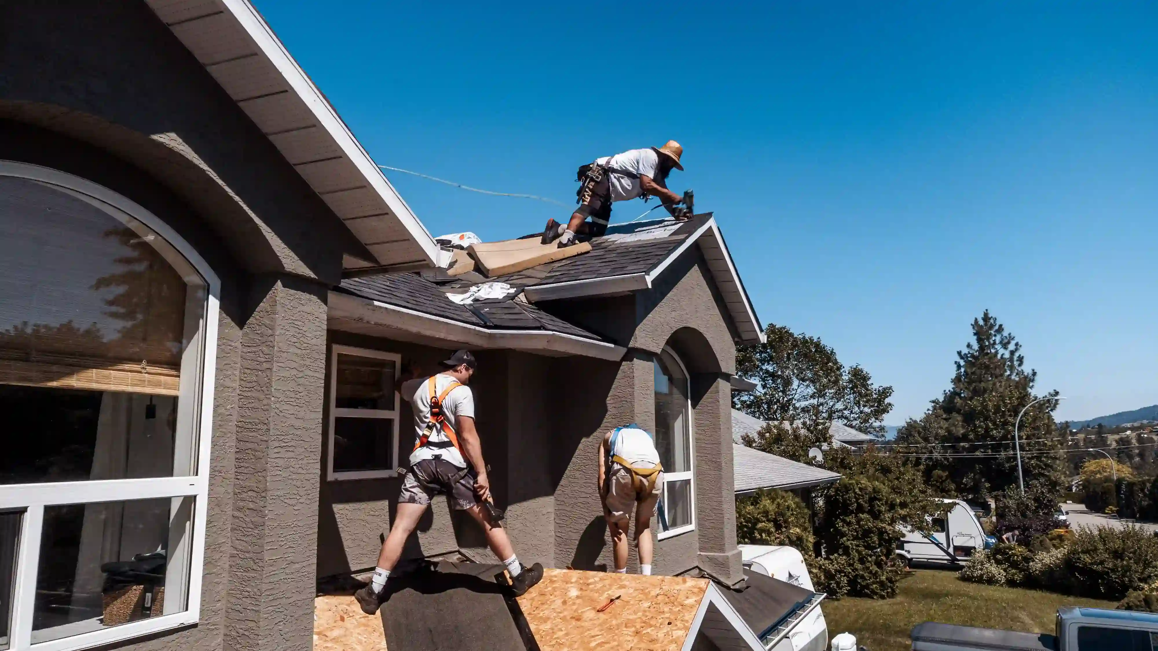 workers on roof of house to fix windows