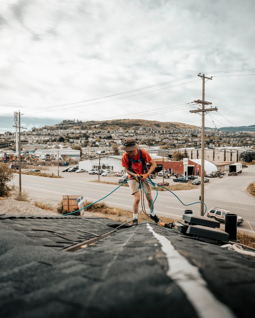 Roof Repairs - worker holding equipment cords during repairs