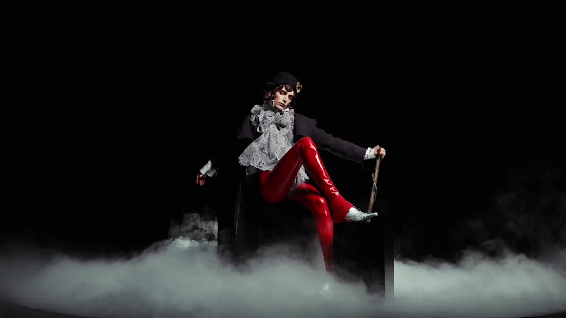 Re{form} Zara: a seated character in red boots above low mist.