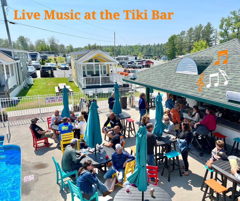 Dave Parker performs live at the Why Knot Tiki Bar in 2025, a vibrant scene of music and good vibes by the water.