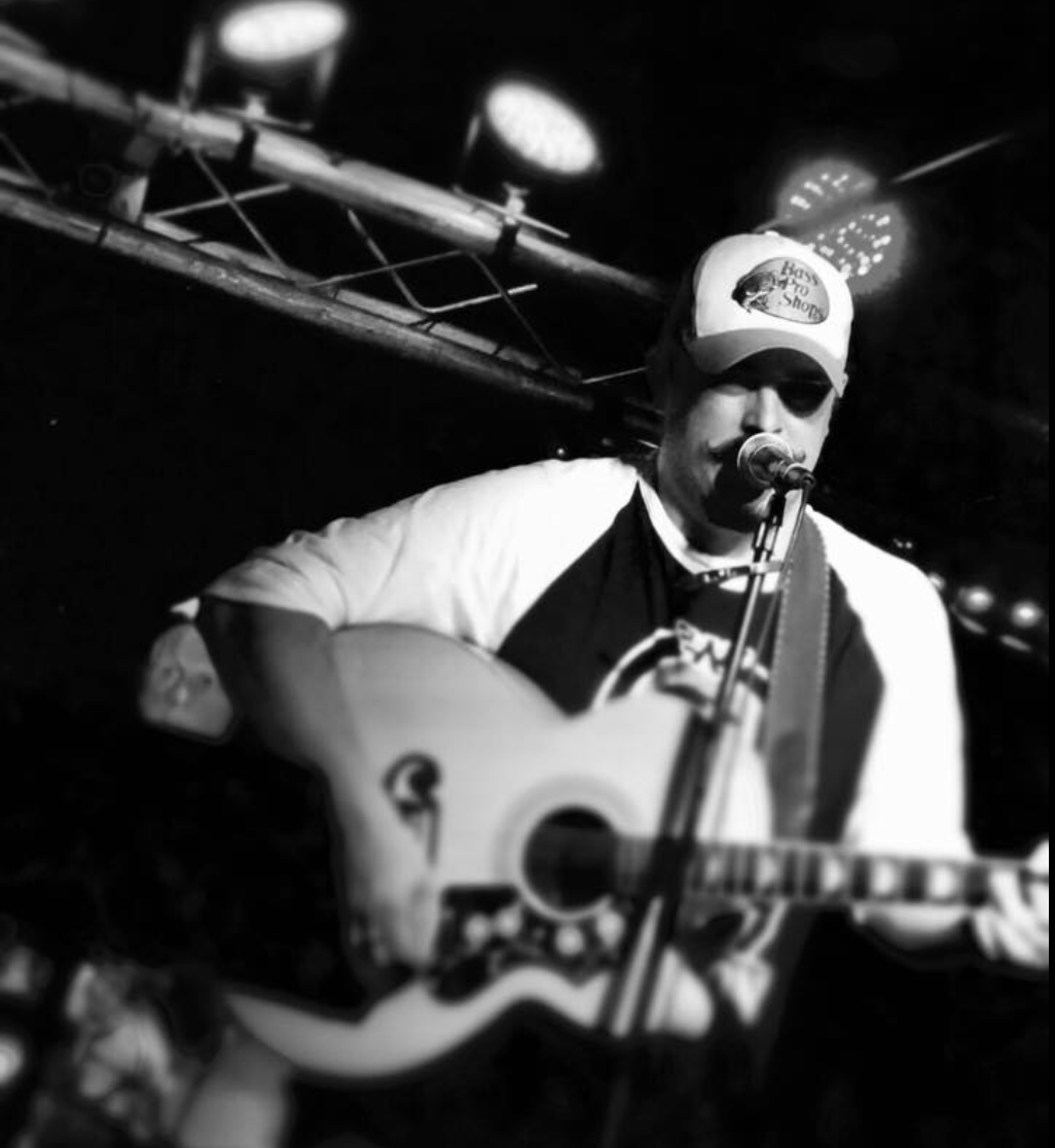 Joe Pritchard live on June 20, 2025: A musician performing on stage at the Why Knot Tiki Bar.