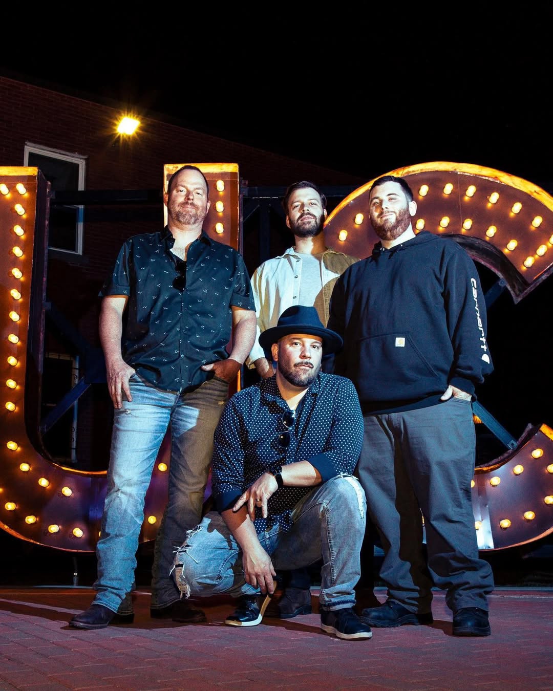 Uncle Charlie & The Meatballs 2025: Energetic band performs blues at a lively outdoor tiki bar by the water at night.