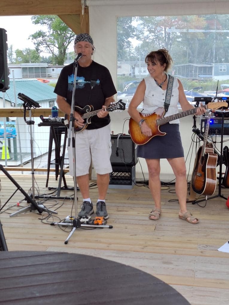 Live Music by Second Nature, 2024: A band performing live at a waterfront venue.