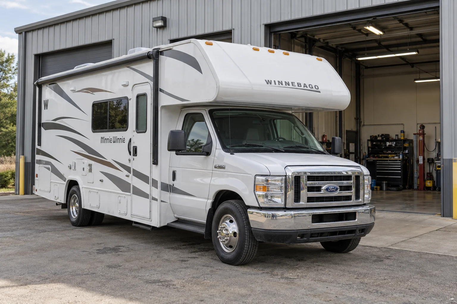 Winnebago motorhome parked outside an RV repair workshop.