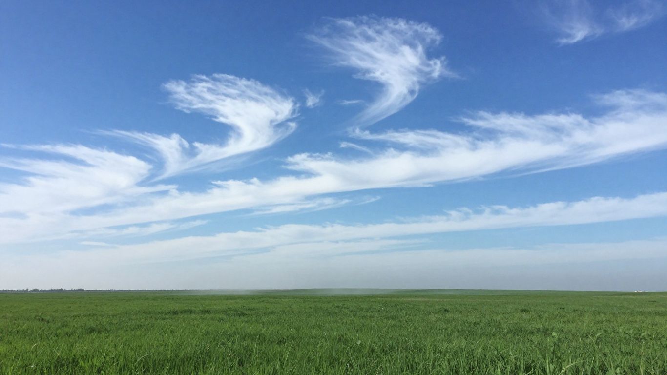 Clear sky above green landscape with a faint haze.