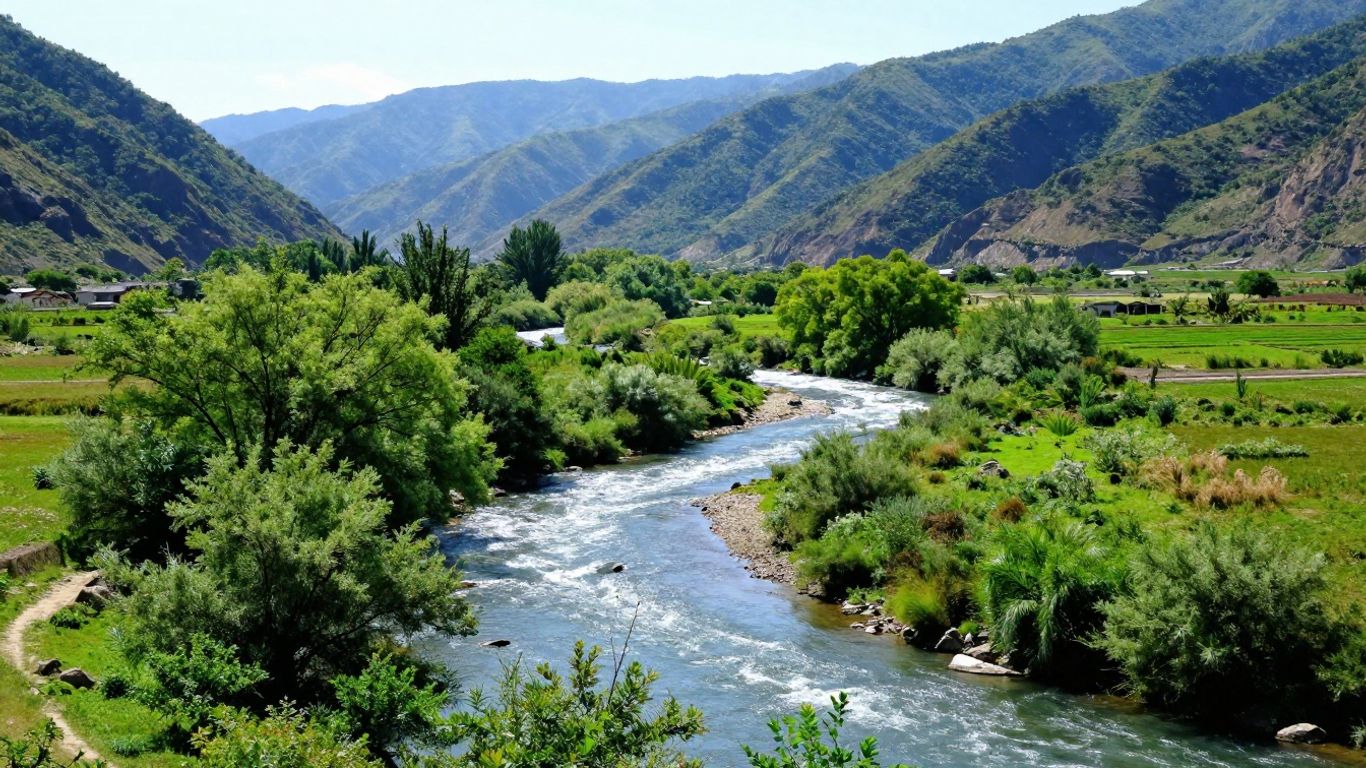 River flowing through a green valley with mountains.