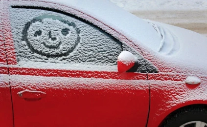 car with snow and a happy face drawn on