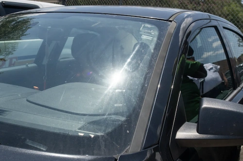 Light reflecting on a car windshield showing contaminates