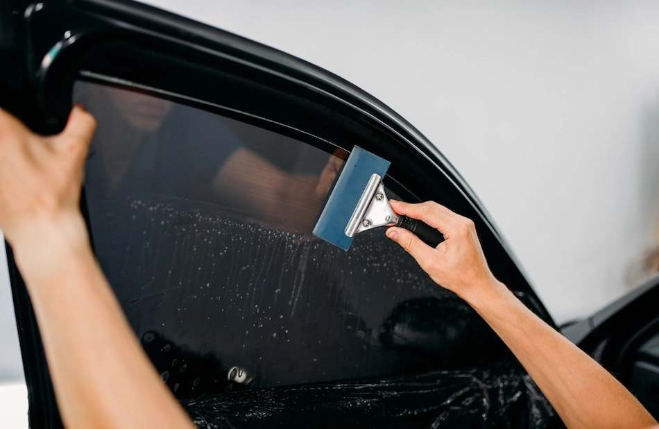 a man tinting a driver's side window