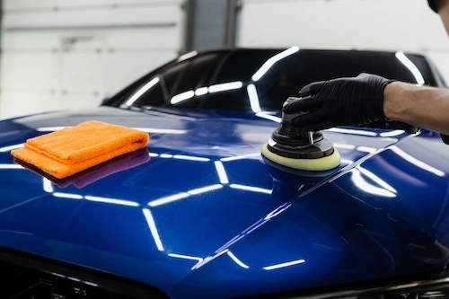 polishing the hood of a blue car