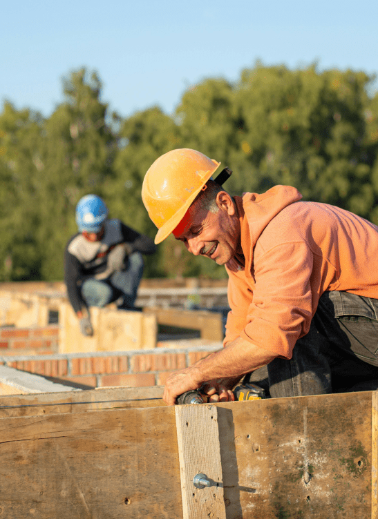 Ouvrier maçon qualifié posant des briques traditionnelles, et montrant son expertise d’artisan.