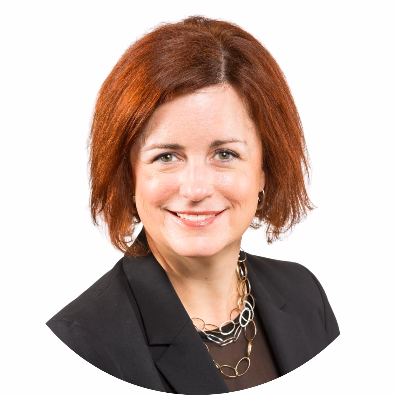 Smiling woman with short auburn hair wearing a black blazer and layered gold chain necklace.