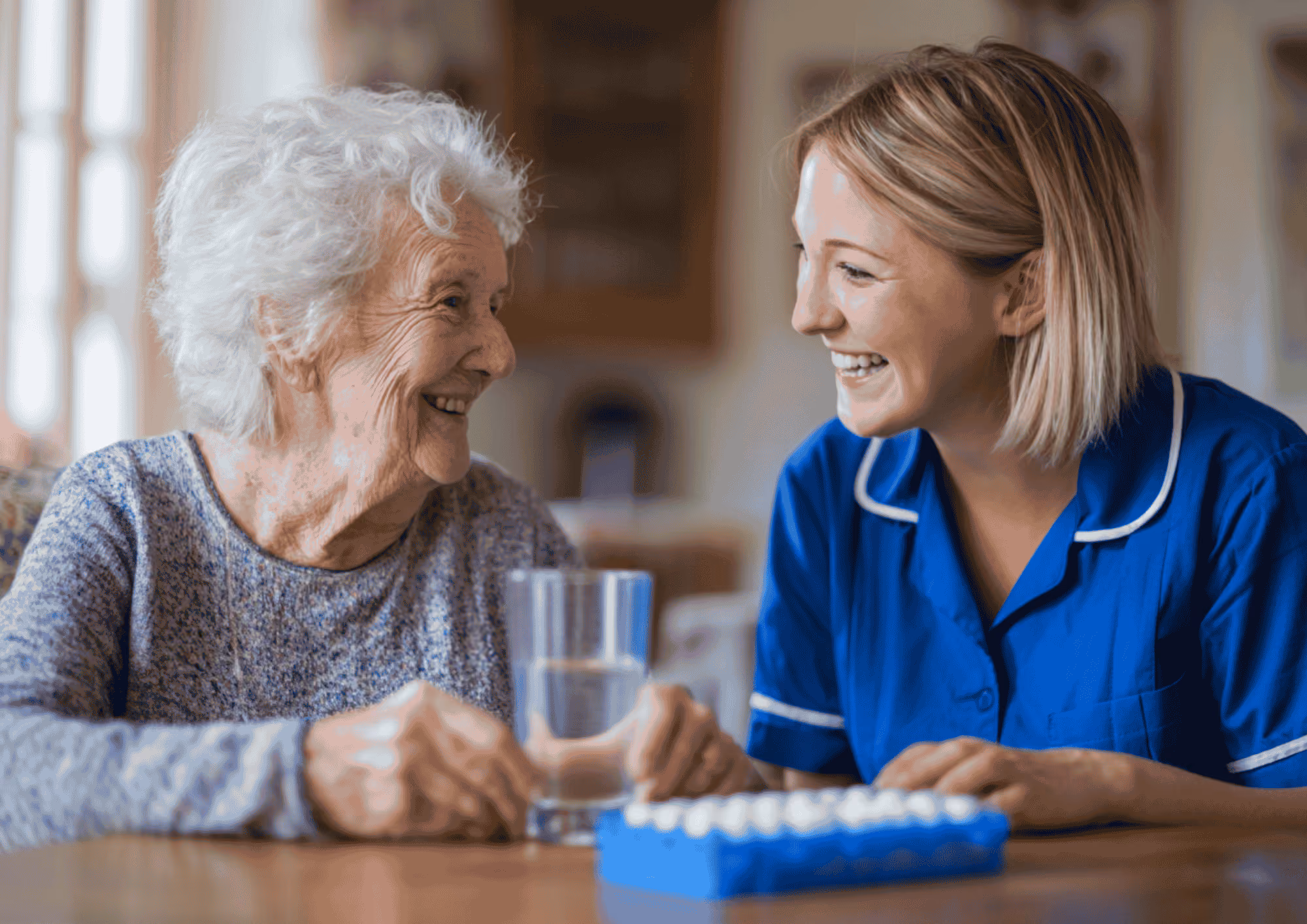 Image of a smiling carer and client. The carer is assisting the client with taking her medication.