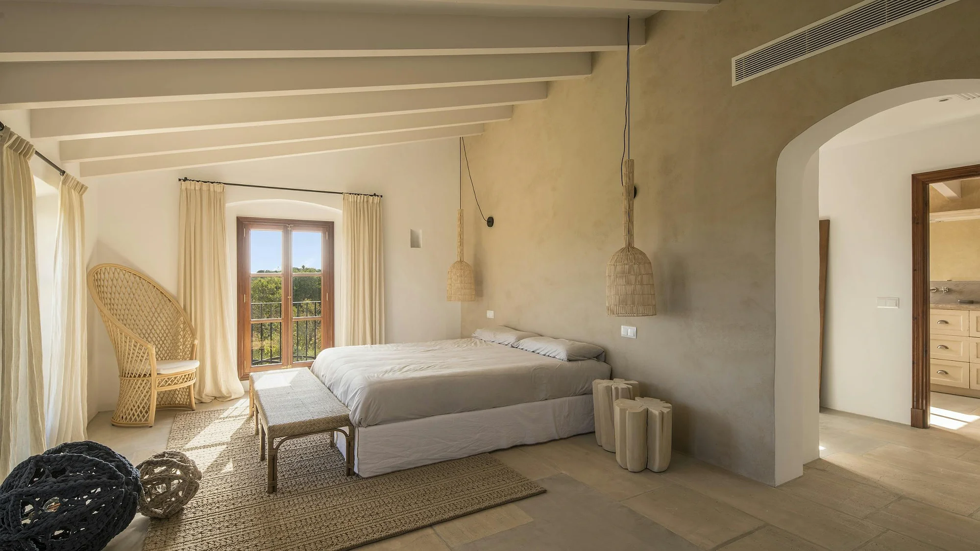 Elegant master bedroom in ByMilagro luxury villa Mallorca with natural light and rustic Mediterranean design