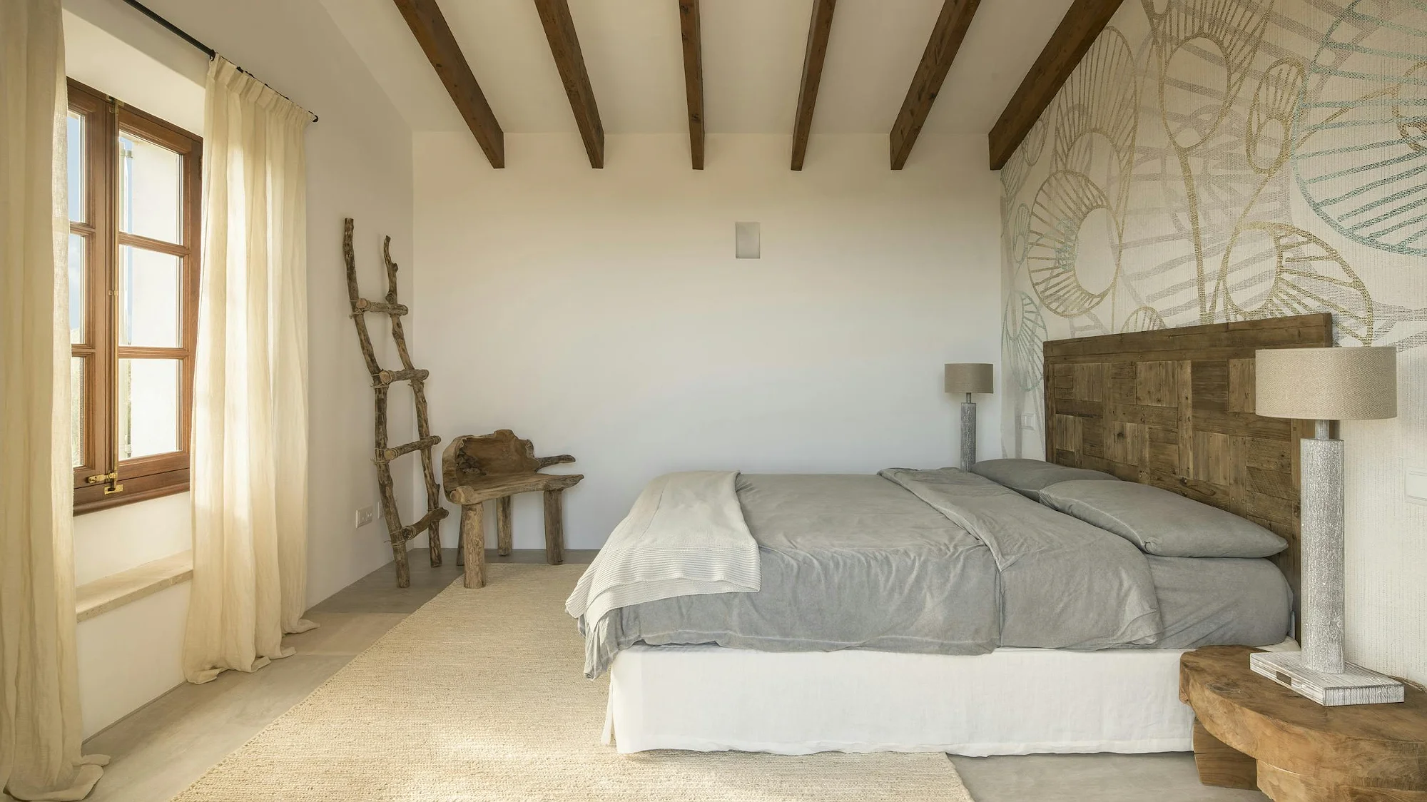 Cozy bedroom with wooden headboard and modern decor in ByMilagro luxury rental villa Mallorca