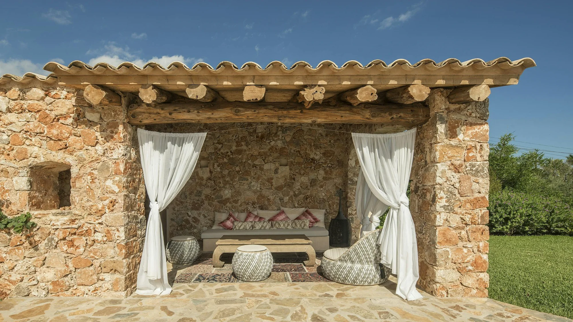 Lounge area with sofas and white curtains at ByMilagro luxury villa rental in Mallorca