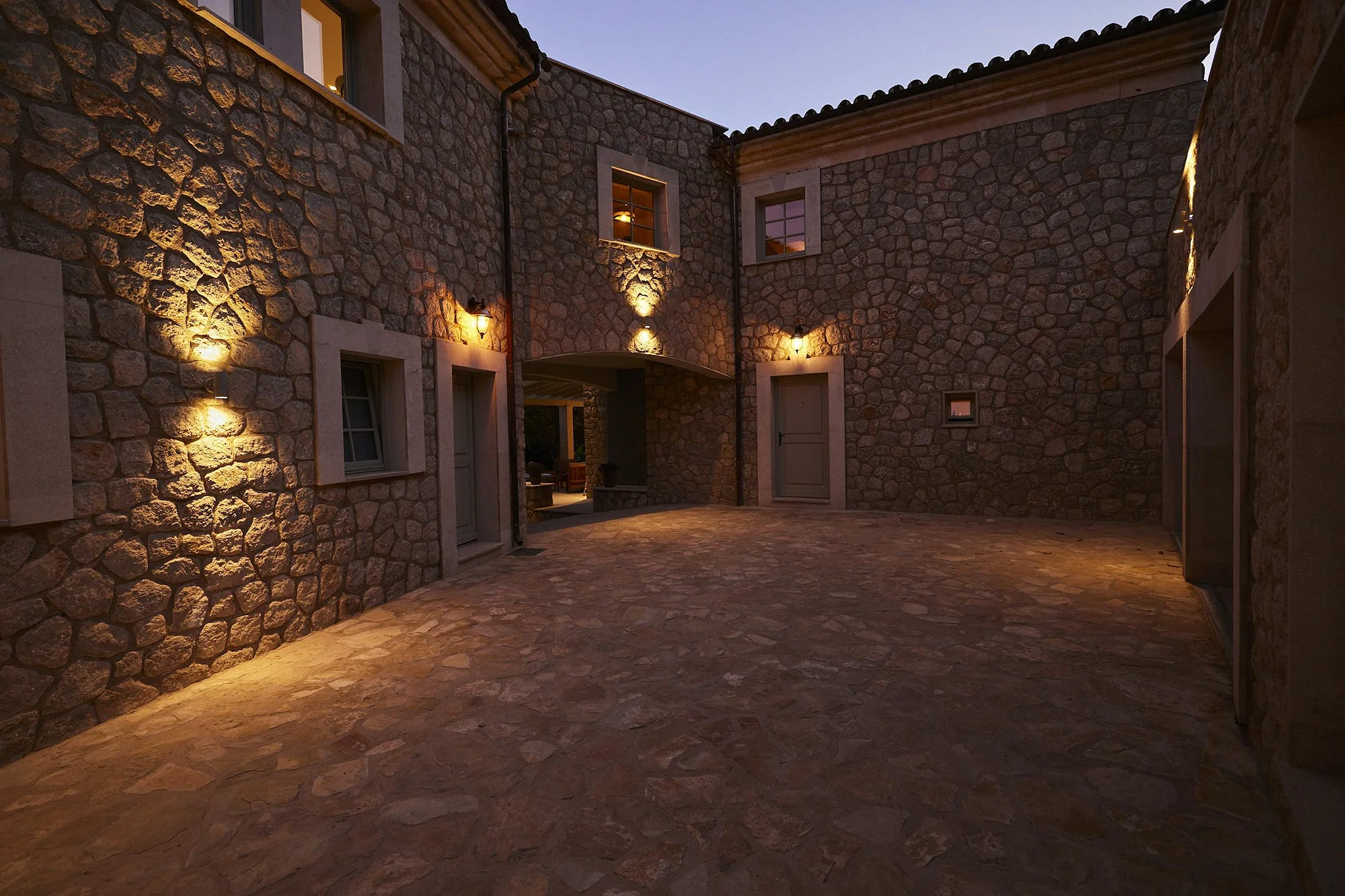 Stone courtyard illuminated at night in ByMilagro luxury rental villa Mallorca