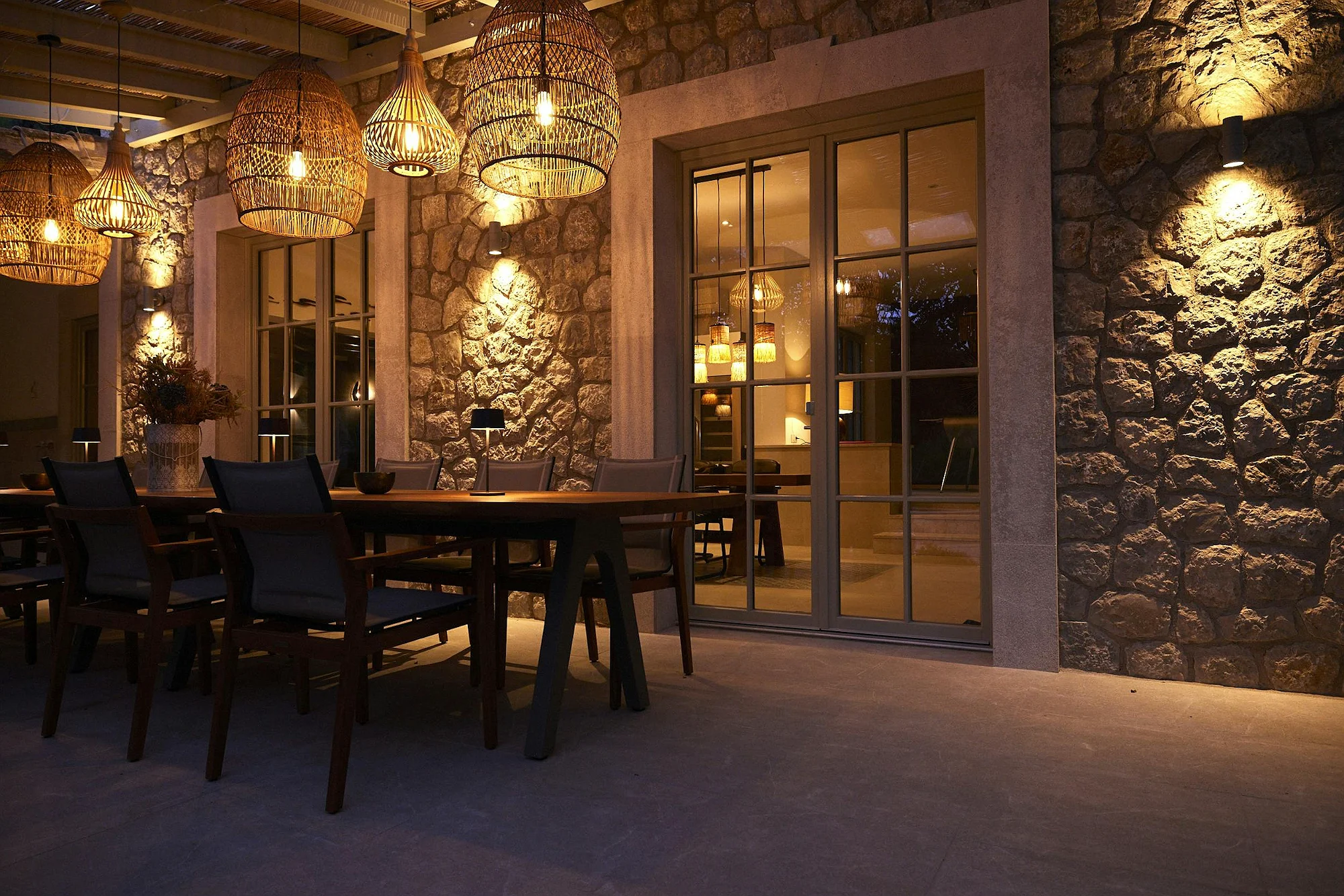 Evening outdoor dining area at ByMilagro luxury villa Mallorca with stone walls and warm lighting