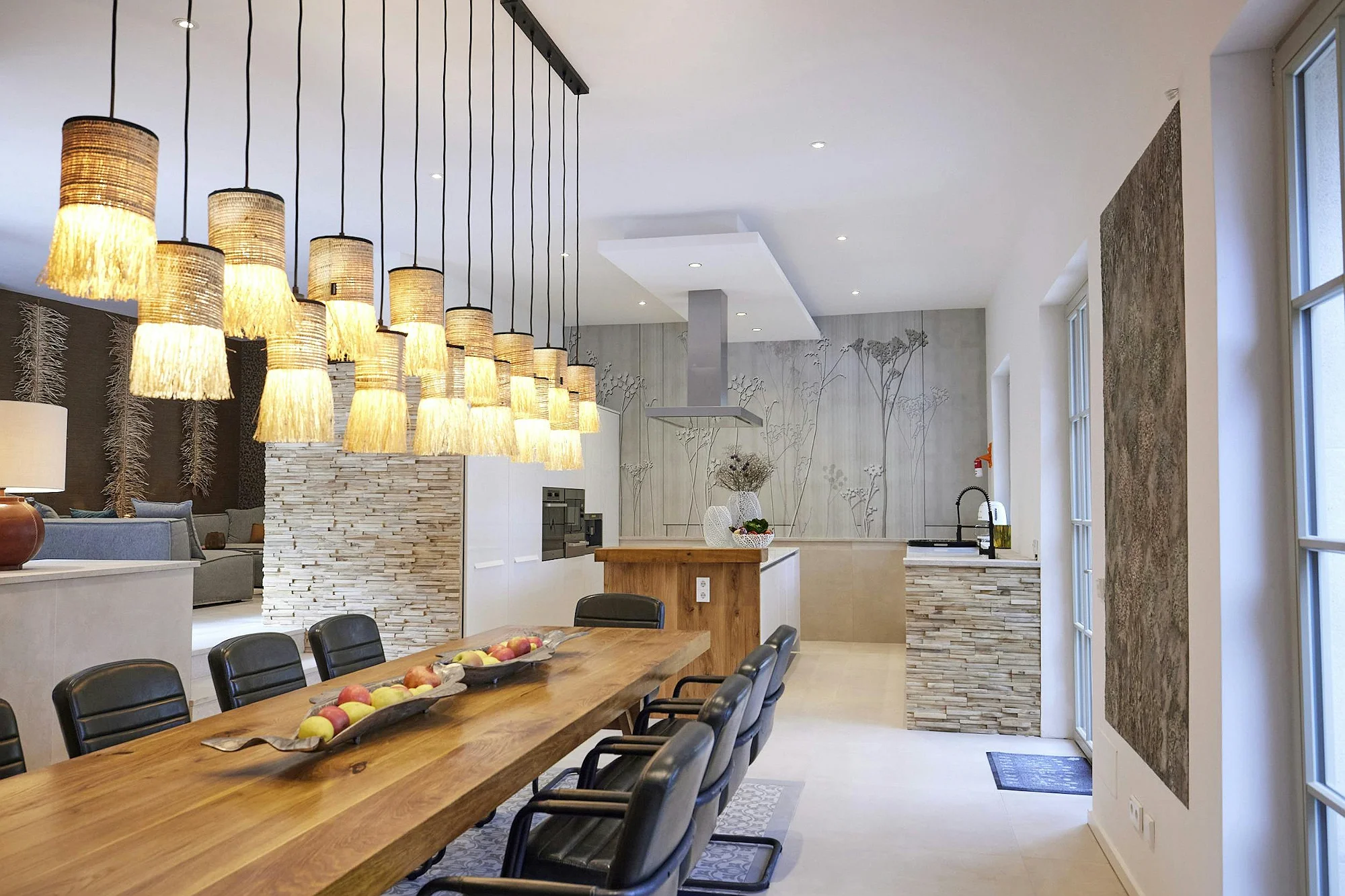 Dining area with long wooden table and modern kitchen at ByMilagro luxury villa Mallorca
