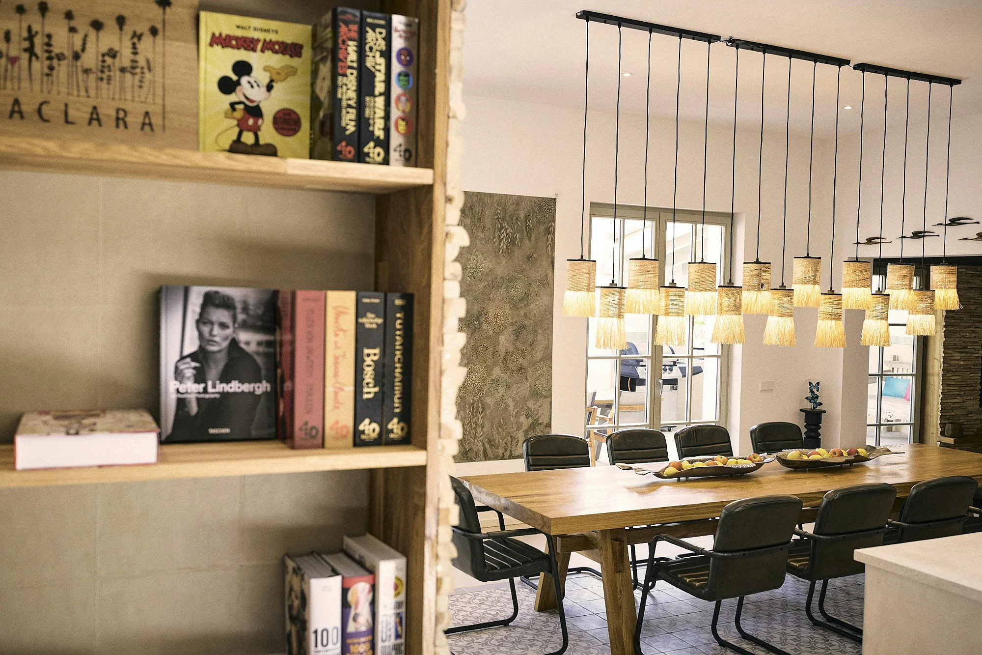 Dining room with long wooden table and designer hanging lights in ByMilagro luxury villa Mallorca