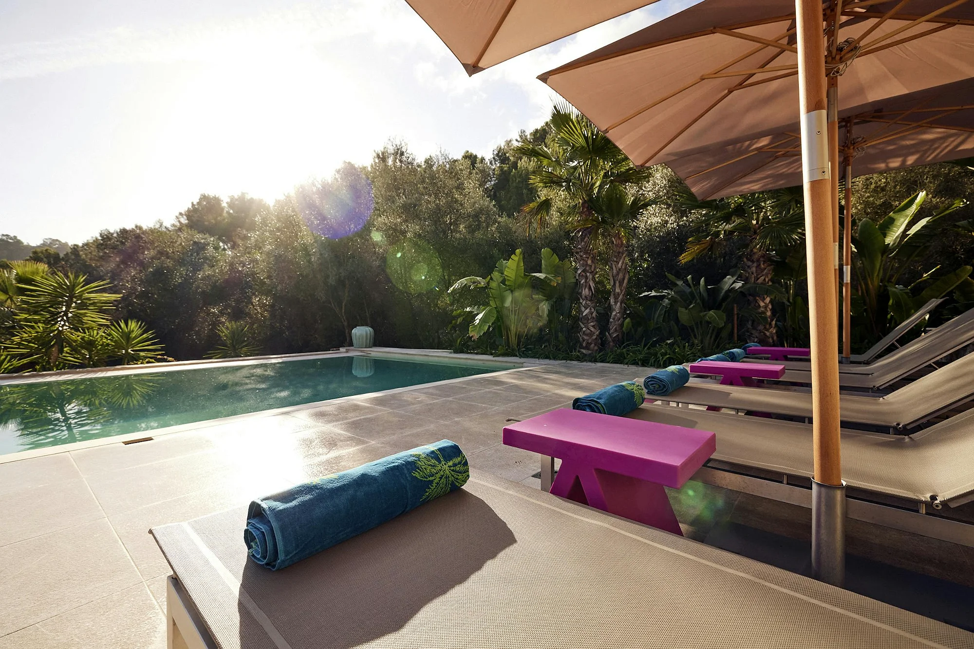 Sun loungers with umbrellas by the pool at ByMilagro luxury villa Mallorca