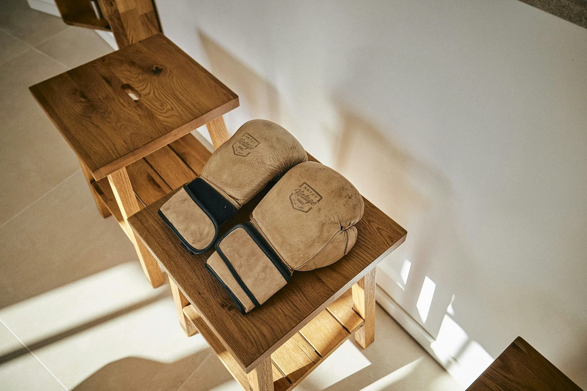 Vintage leather boxing gloves on wooden bench at ByMilagro villa Mallorca